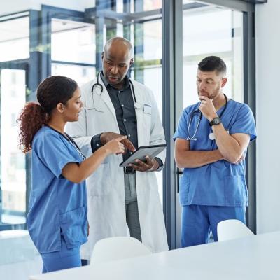 stock-medical-team-talking-informal-pointing-at-tablet